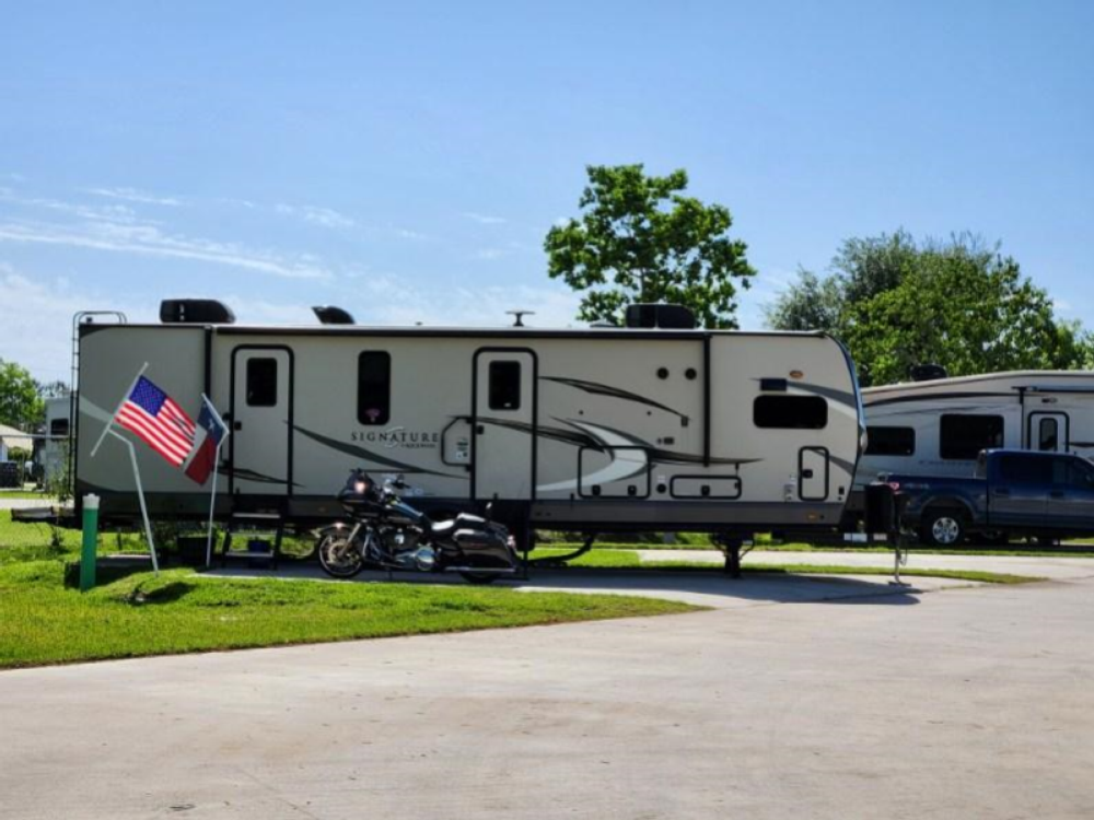 RV with motorcycle parked in front at Jackie's Place RV Resort