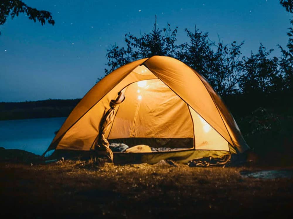 A tent near the water at dusk