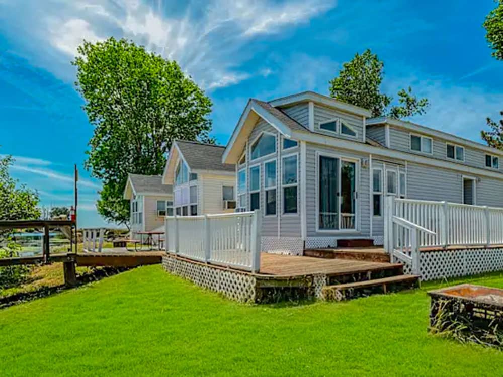 A rental with a porch, surrounded by grass