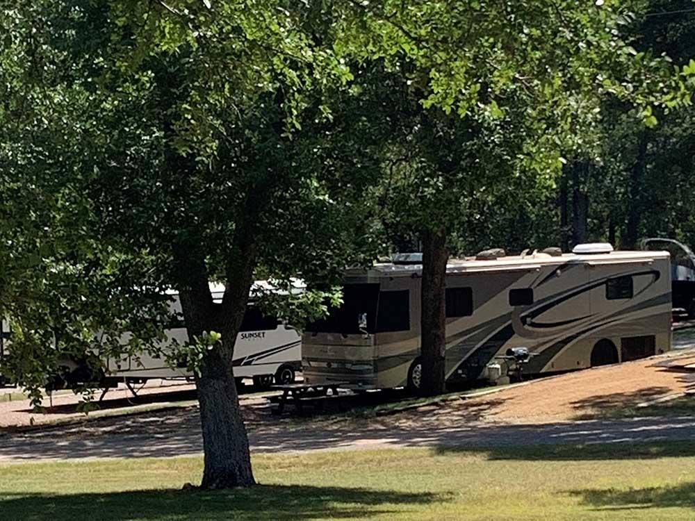 A motorhome and trailer parked in sites at GONE FISHING RV RESORT
