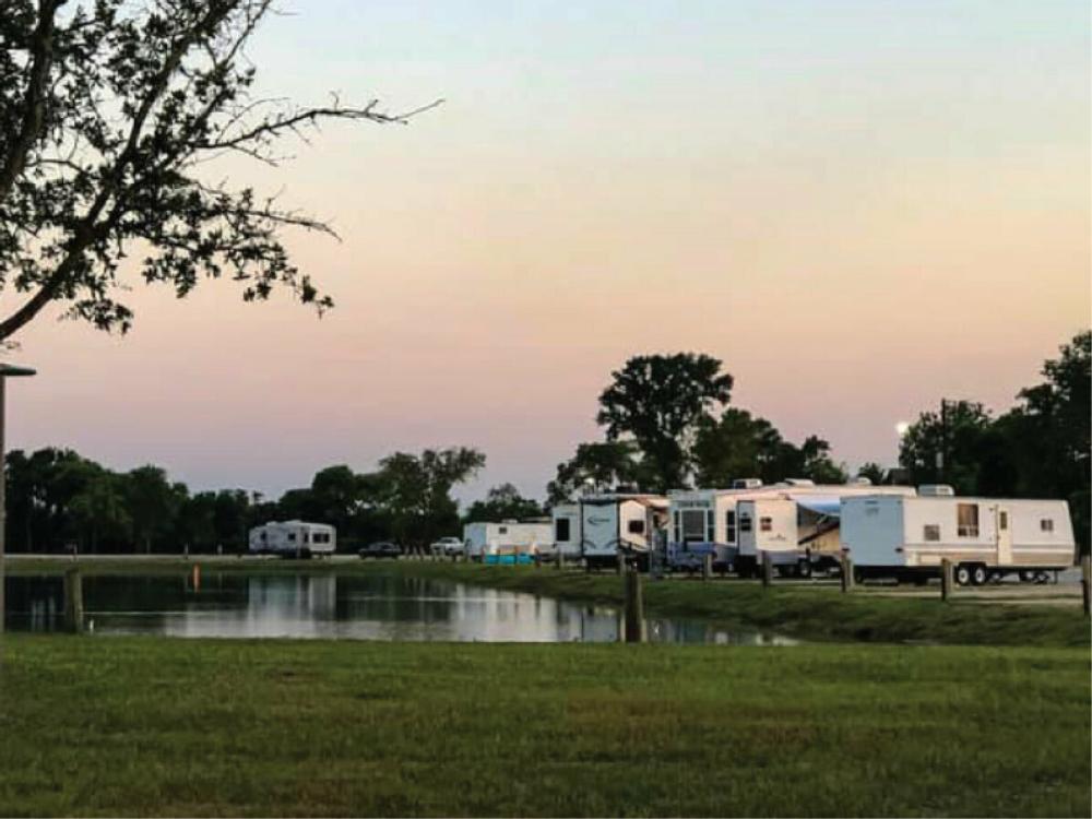 RV sites surround the pond at sunset at The Bend RV Park