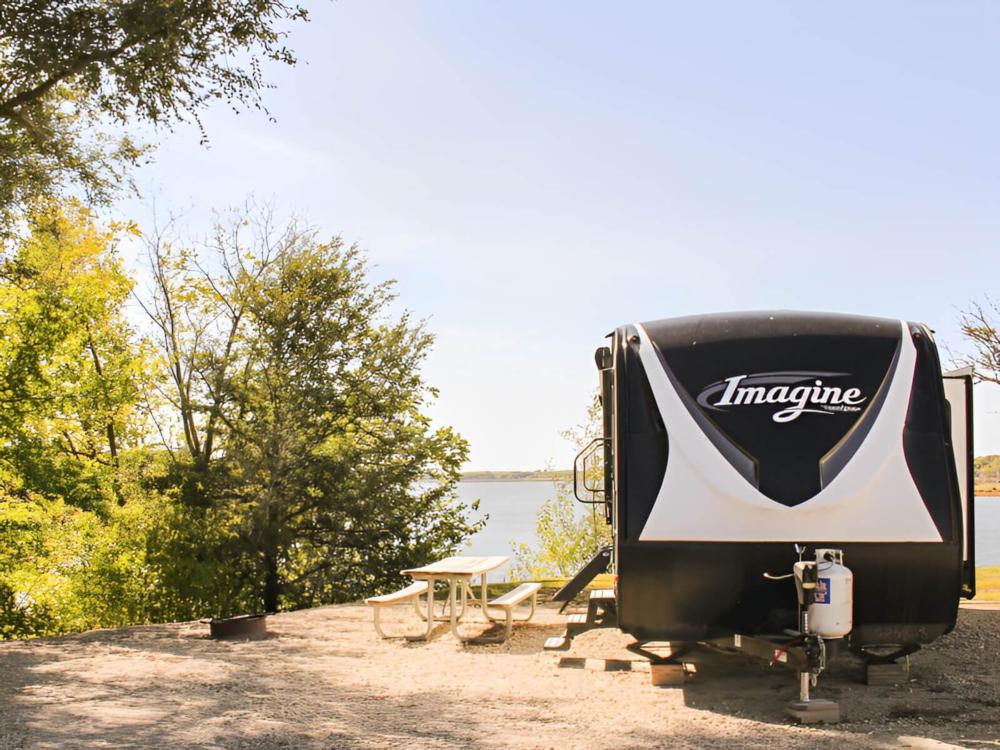 An RV parked in a site by the river
