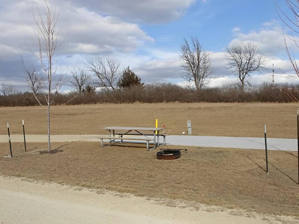 A large RV site with table and fire pit