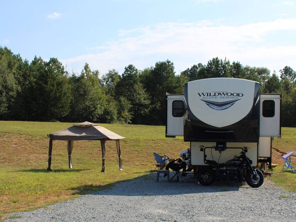 A fifth wheel and motorcycle at a site