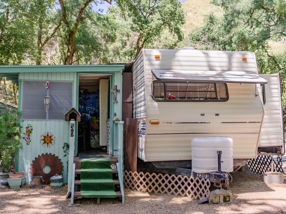 Parked trailer with covered patio at Blue Lakes Village RV Park