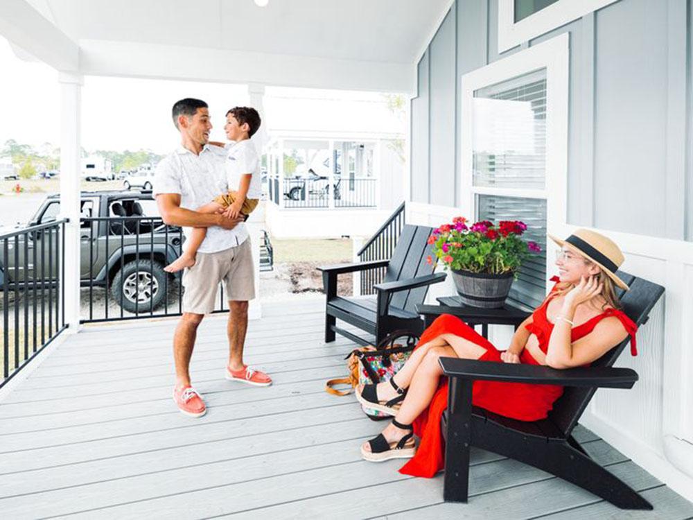 A family on the porch of a rental at OCEANS RV RESORT