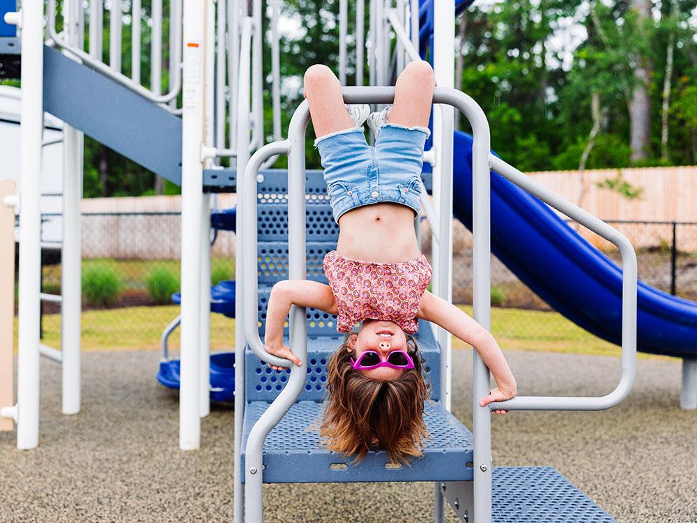 A little girl on the playground equipment at OCEANS RV RESORT