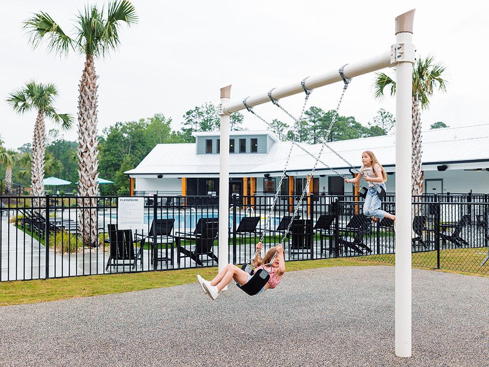 Two girls playing on the swings at OCEANS RV RESORT