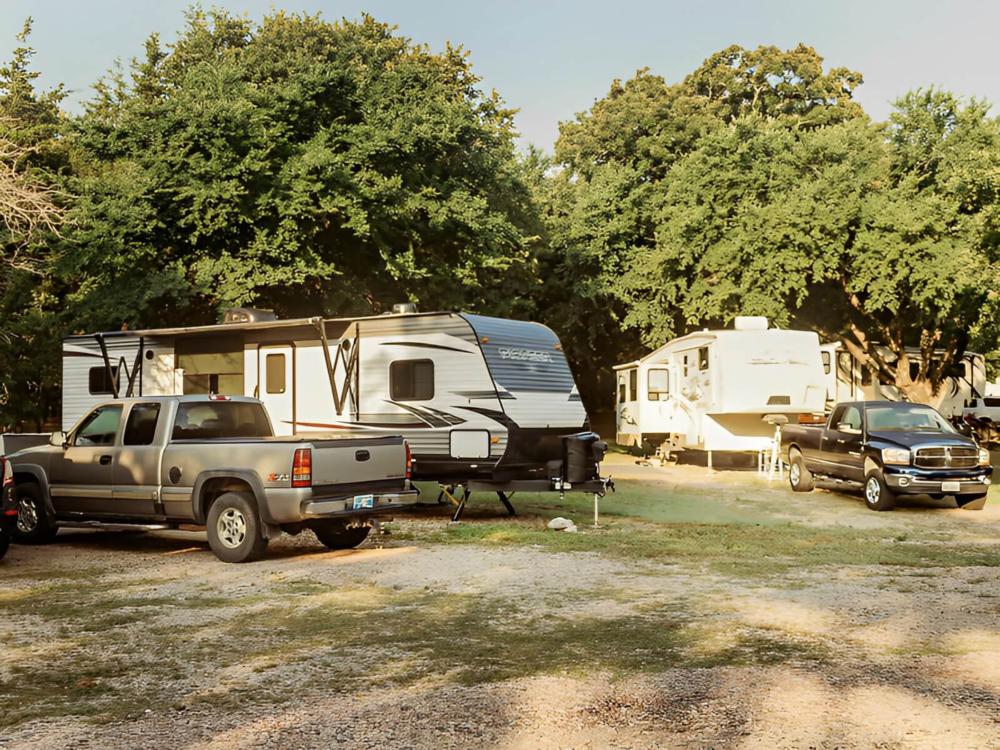 Trailers parked near pickup trucks at Country Dream RV Park