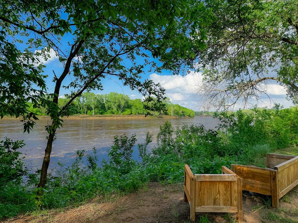 Seating area along the river at RIVERSHIRE RV RESORT & CAMPING