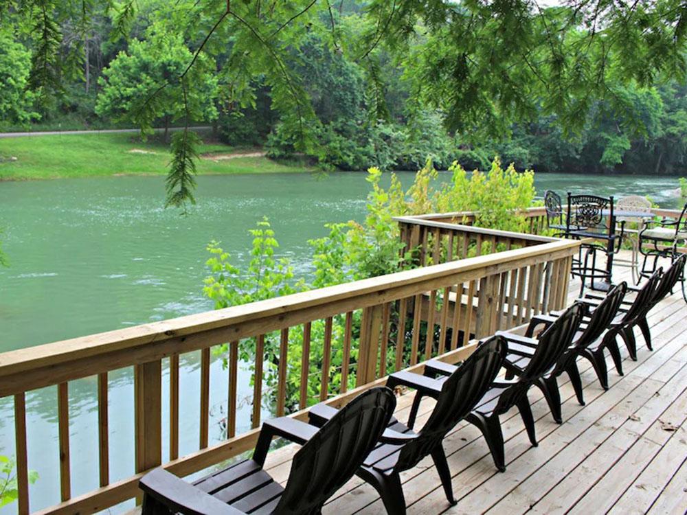 Chairs line the deck along the river at RIVERSHIRE RV RESORT & CAMPING