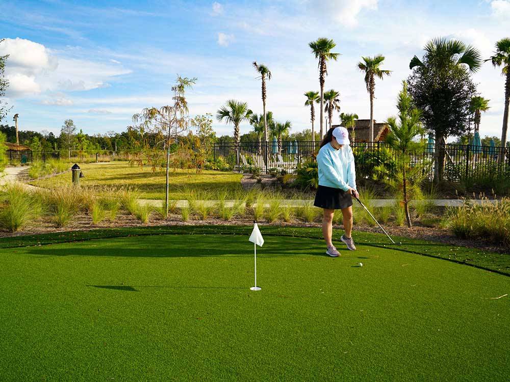 A lady playing golf at TROPIC HIDEAWAY RV RESORT