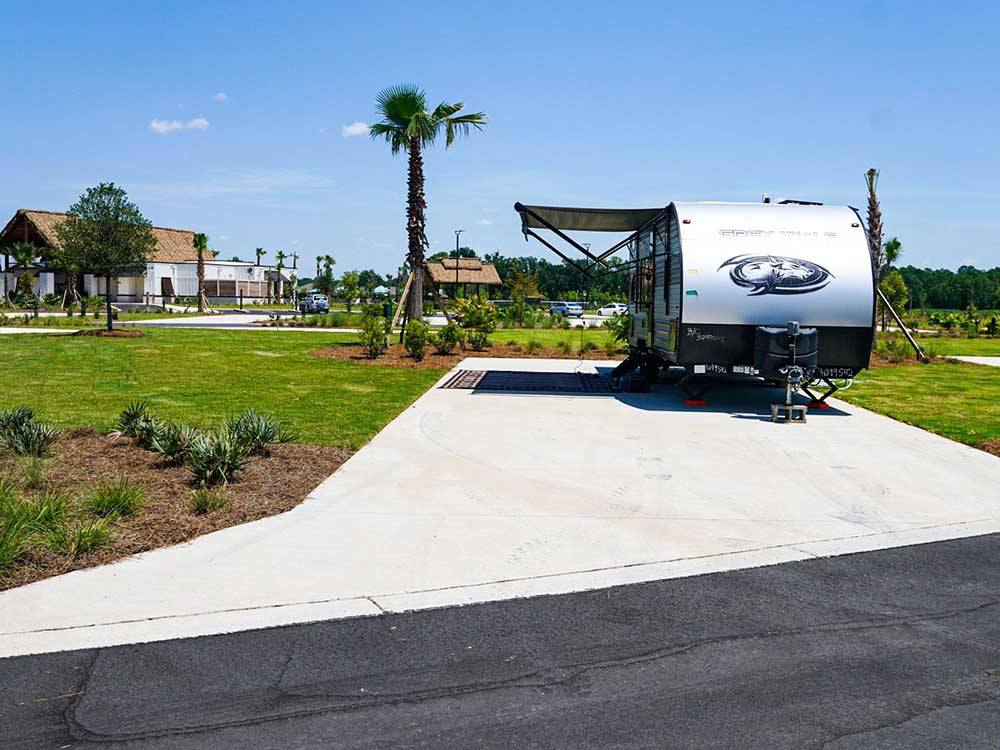 A travel trailer parked in a paved site at TROPIC HIDEAWAY RV RESORT
