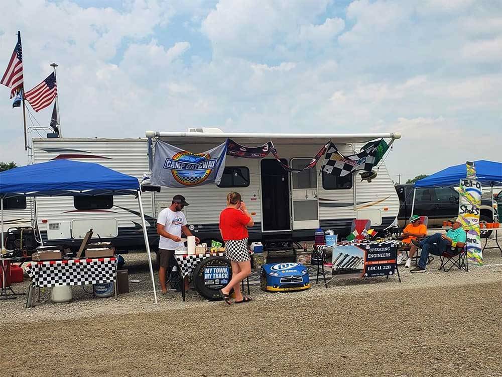 A family sitting in front of their trailer at WORLD WIDE TECHNOLOGY RECEWAY CAMPGROUND