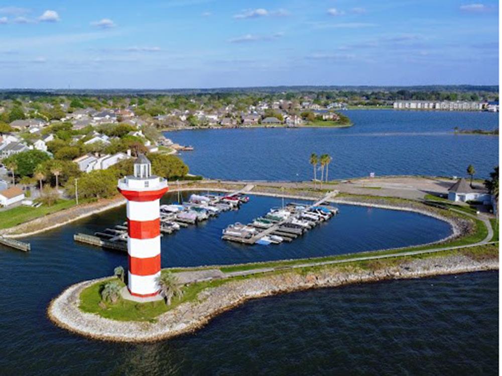 Aerial view of the marina and lighthouse at TWISTED PARROT LUXURY RV RESORT