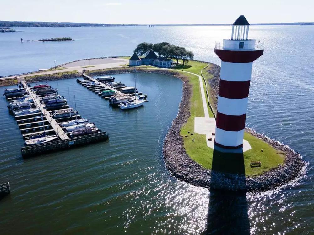 Boats at the marina and lighthouse at TWISTED PARROT LUXURY RV RESORT