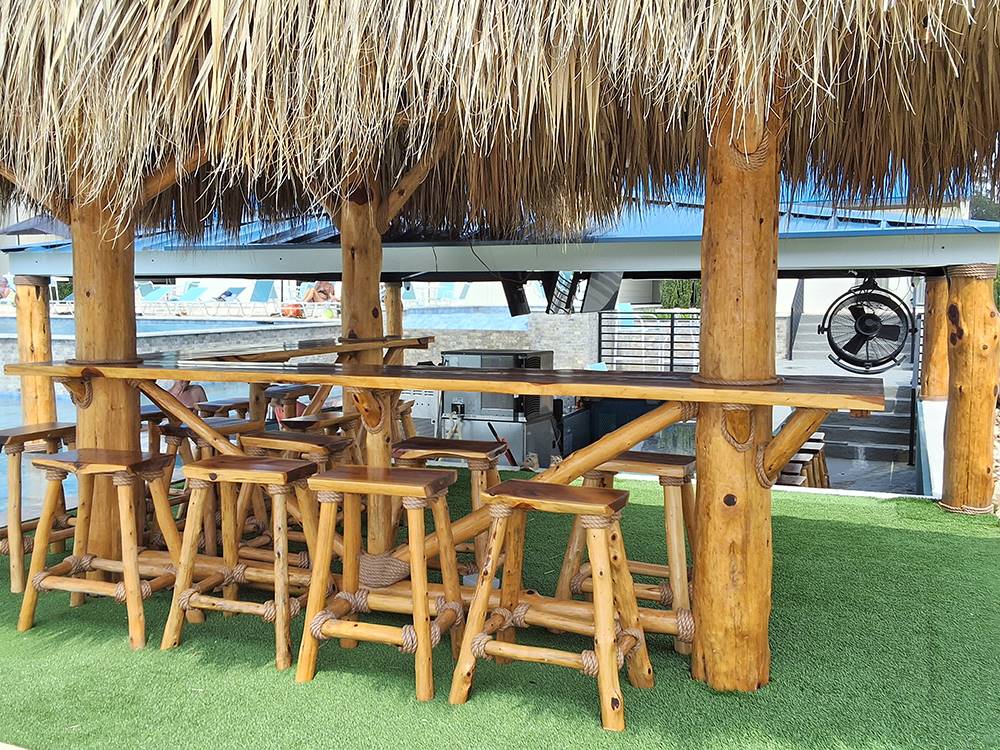 A tiki bar under a shaded thatched roof