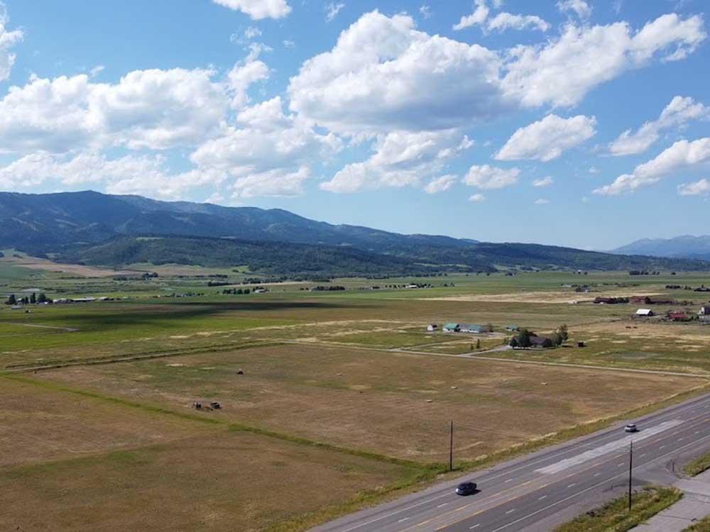 Aerial view of the grassy area and mountains at GRAND BUFFALO RV RESORT