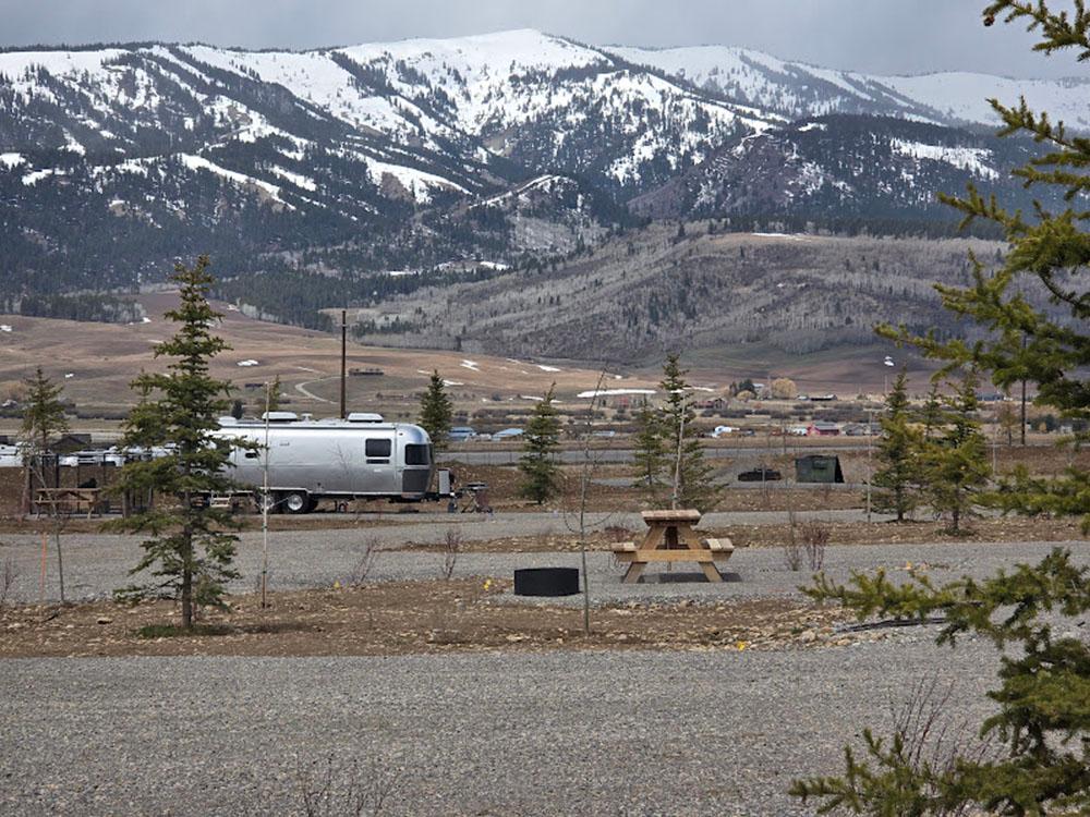 Vintage trailer with snow-capped hills in the distance at GRAND BUFFALO RV RESORT