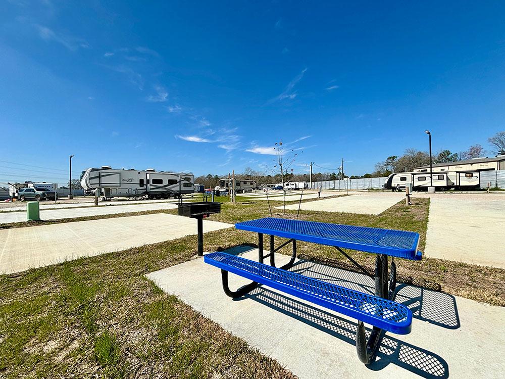 A blue picnic bench and bbq pit at a site at NEW CANEY RV PARK