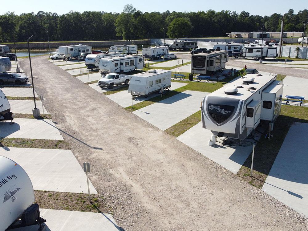Two rows of travel trailers parked in sites at NEW CANEY RV PARK