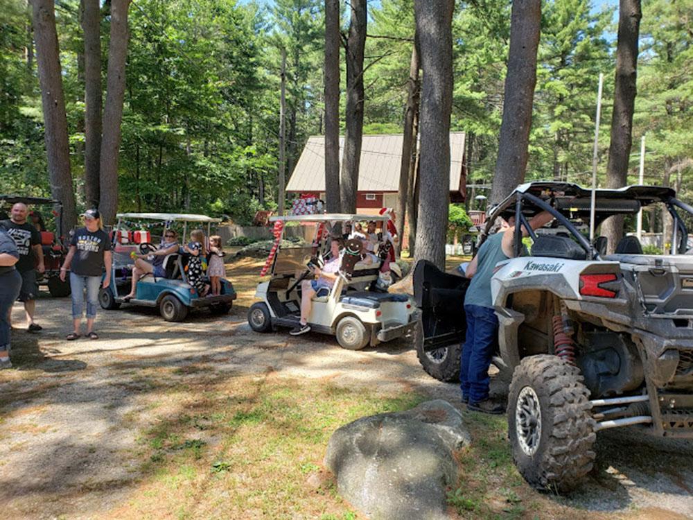 A group of campers in golf carts and ATVs at PEACEFUL PINES FAMILY CAMPGROUND