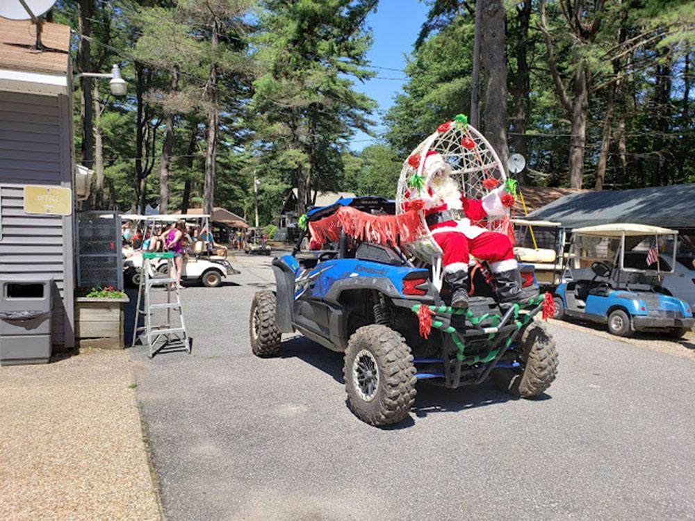 Santa Claus on the back of an ATV at PEACEFUL PINES FAMILY CAMPGROUND