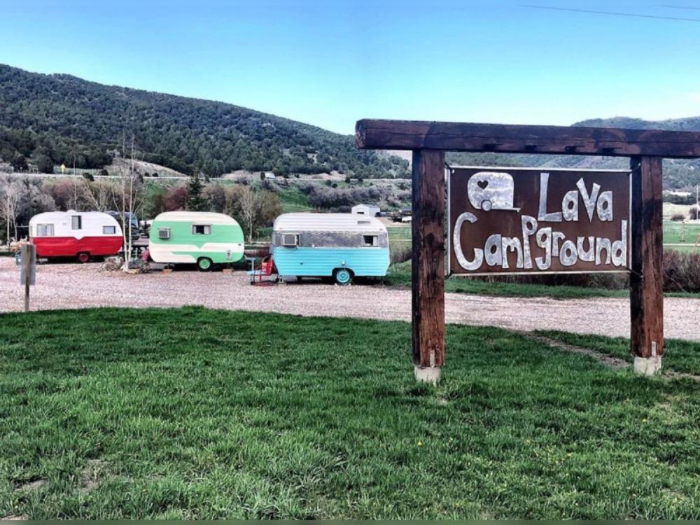 Three vintage trailers and the park sign at Lava Campground