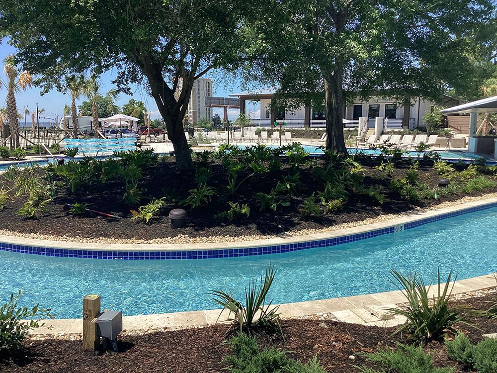 Lazy river with landscaping at GULFPORT LUXURY RV RESORT