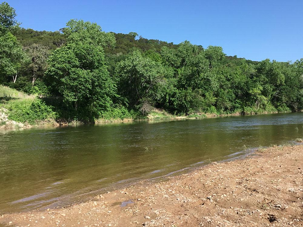A view of the river with trees nearby at BRAZOS RIVER HIDEOUT