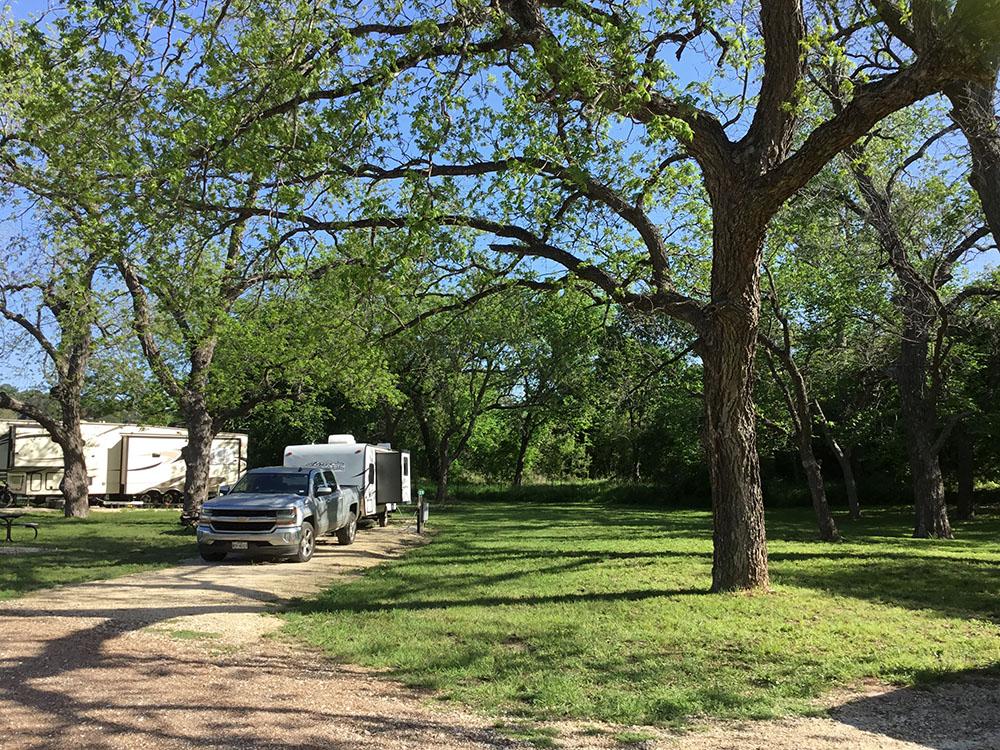 A truck and trailer backed in at a site at BRAZOS RIVER HIDEOUT