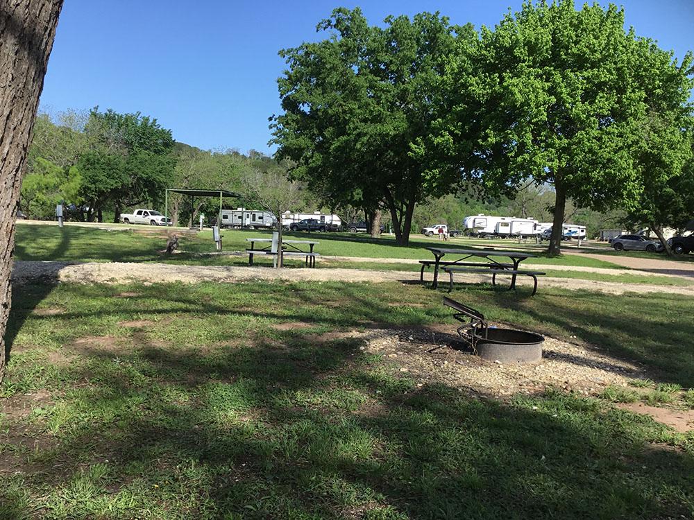Picnic benches and fire pit at RV sites at BRAZOS RIVER HIDEOUT