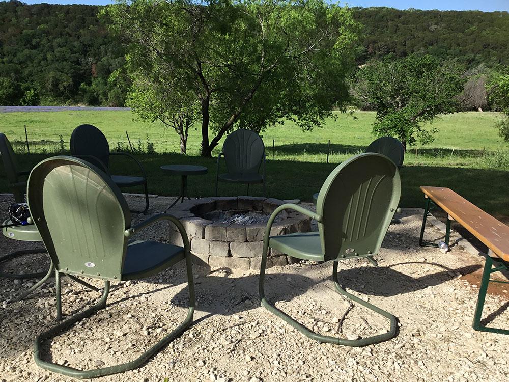 Green chairs around a fire pit at BRAZOS RIVER HIDEOUT