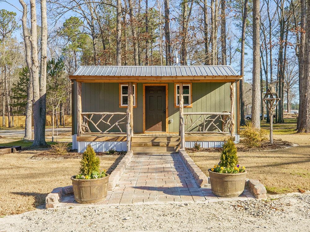 A front view of one of the rustic rental cabins at SANWAR RV PARK & RESORT