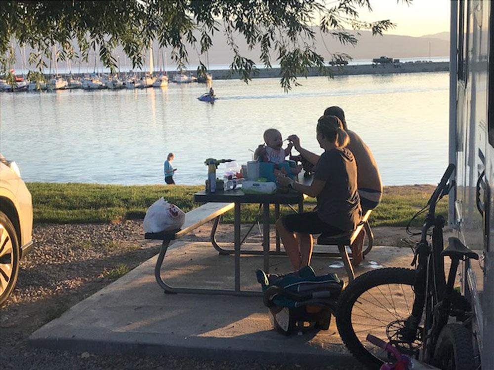 People at a picnic table at LAKE SHORE RV PARK