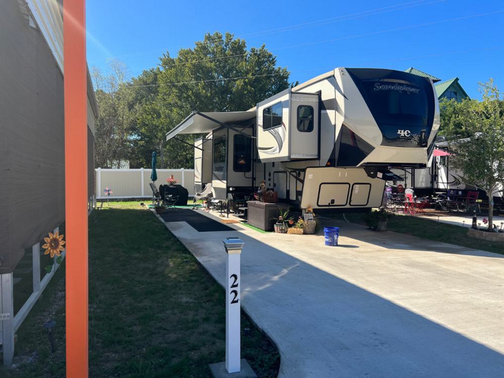 A fifth wheel in a paved site at Aledo Acres RV Park