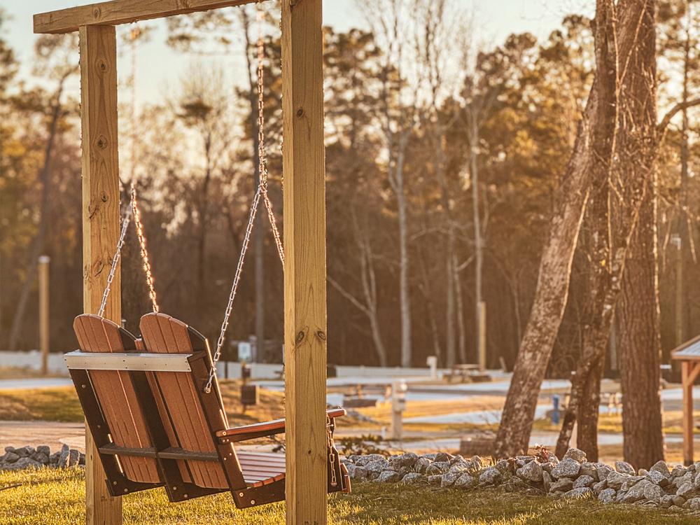 A wooden swing at CROOKED OAKS RV PARK