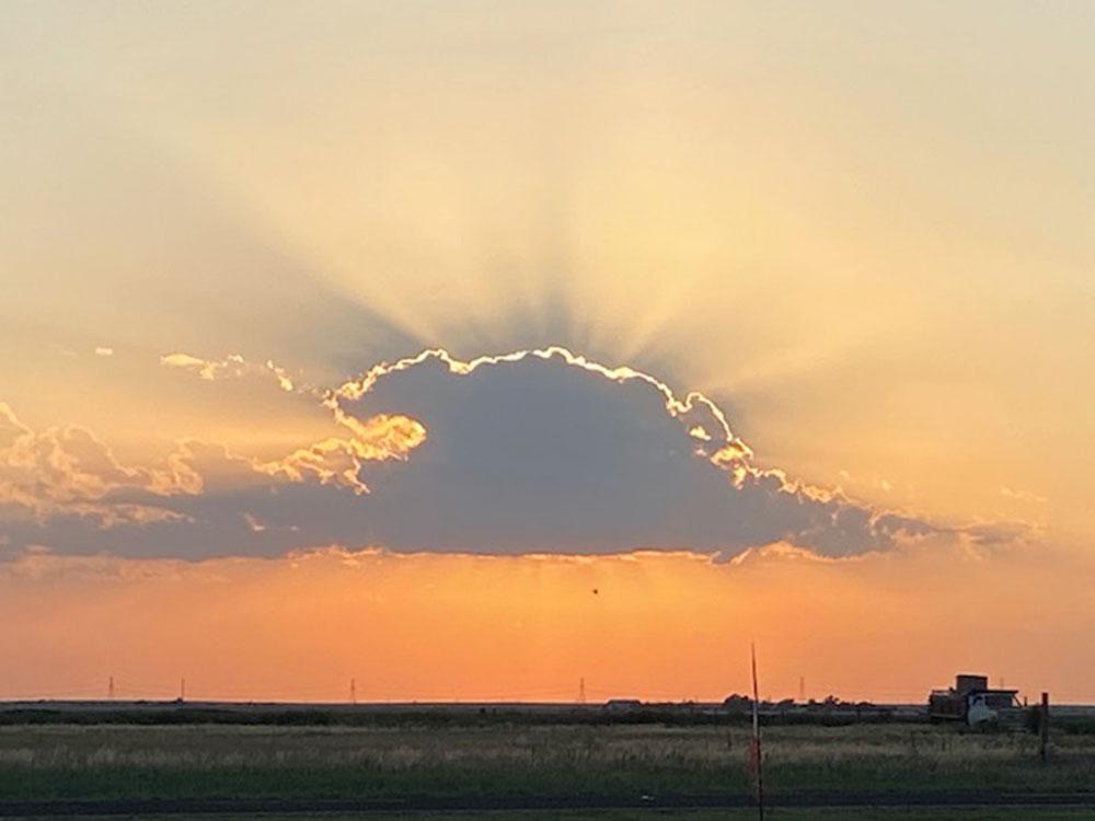 Sunburst behind a cloud at SILVER WIND RV PARK AND CABINS