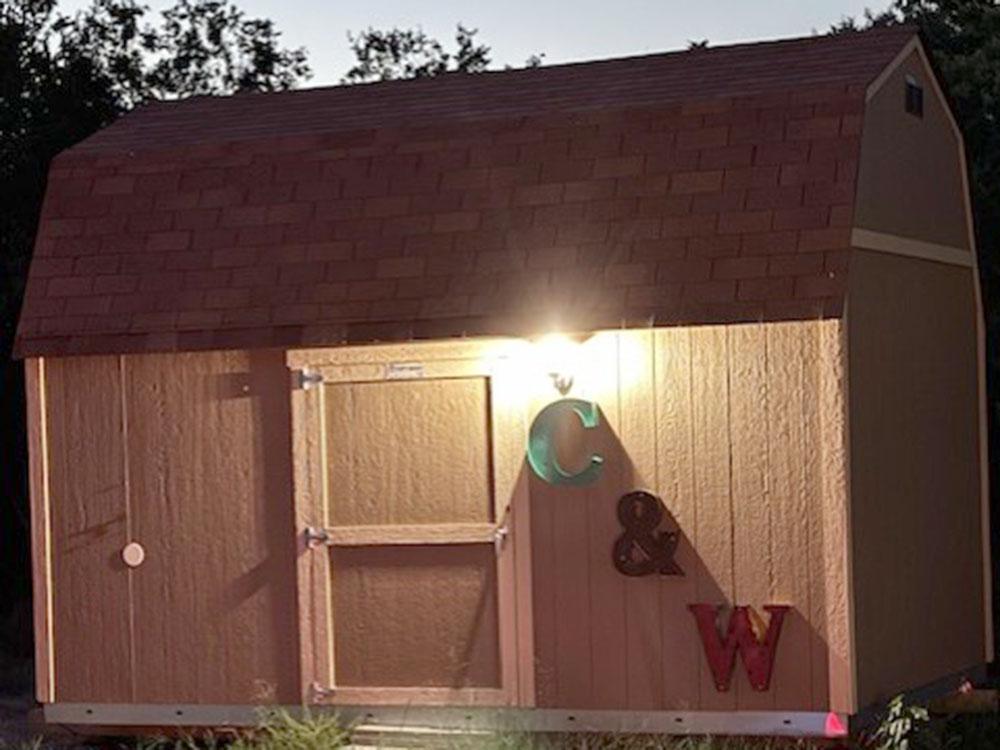 Wood building with light on at C&W RV PARK