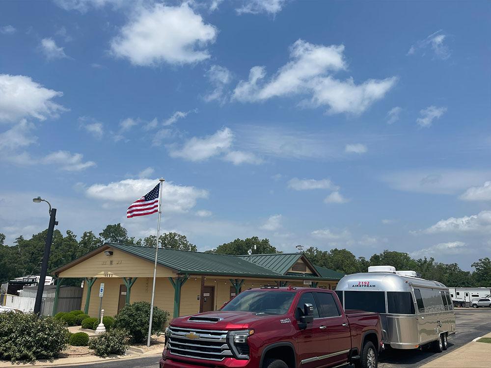 A truck and Airstream trailer passing the office at TIMBER RIDGE RV PARK