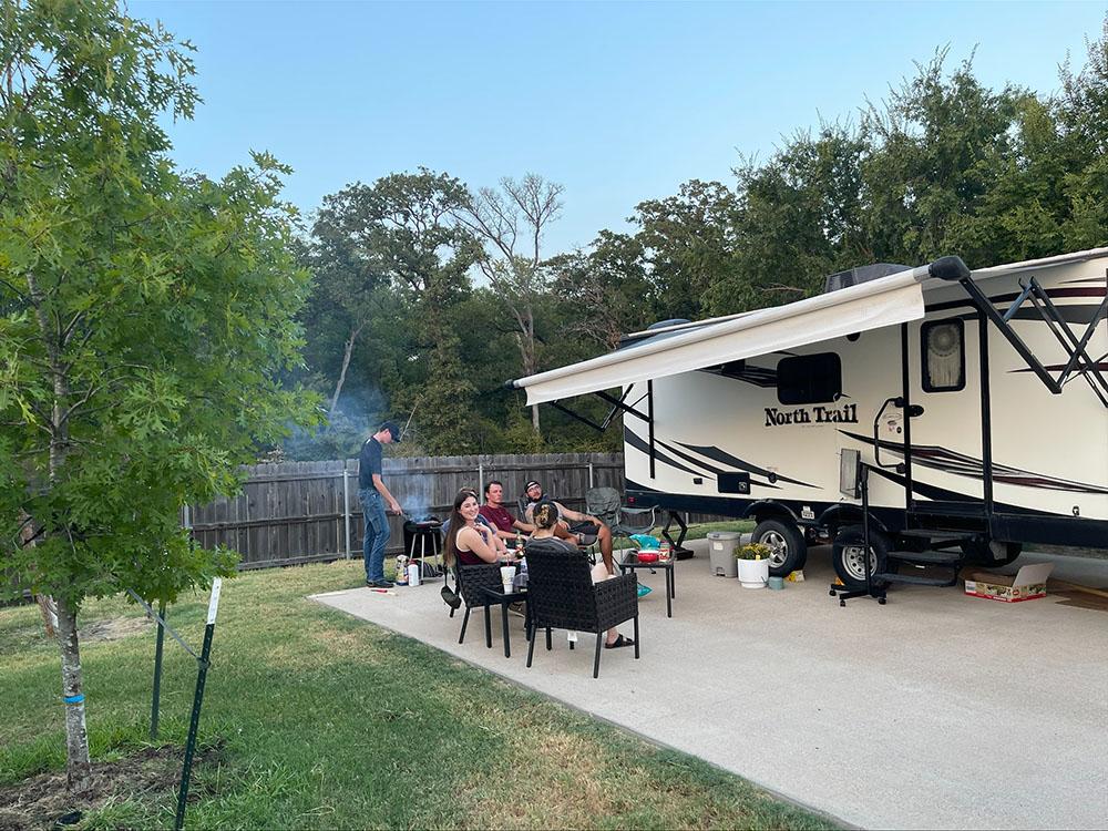 A family barbecuing at their site at TIMBER RIDGE RV PARK