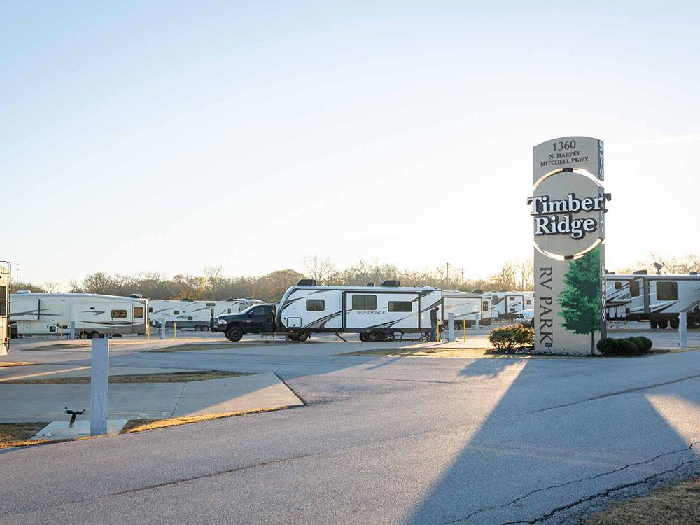 Travel trailers parked by the park sign at TIMBER RIDGE RV PARK