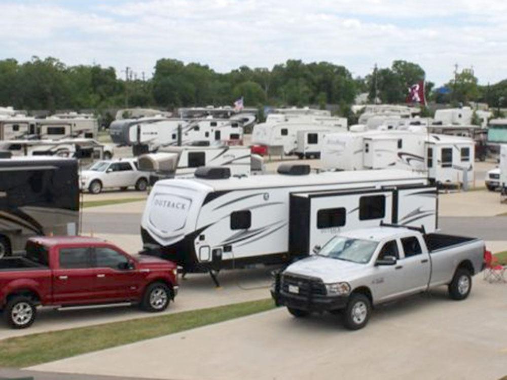 Two trucks parked by a trailer at TIMBER RIDGE RV PARK