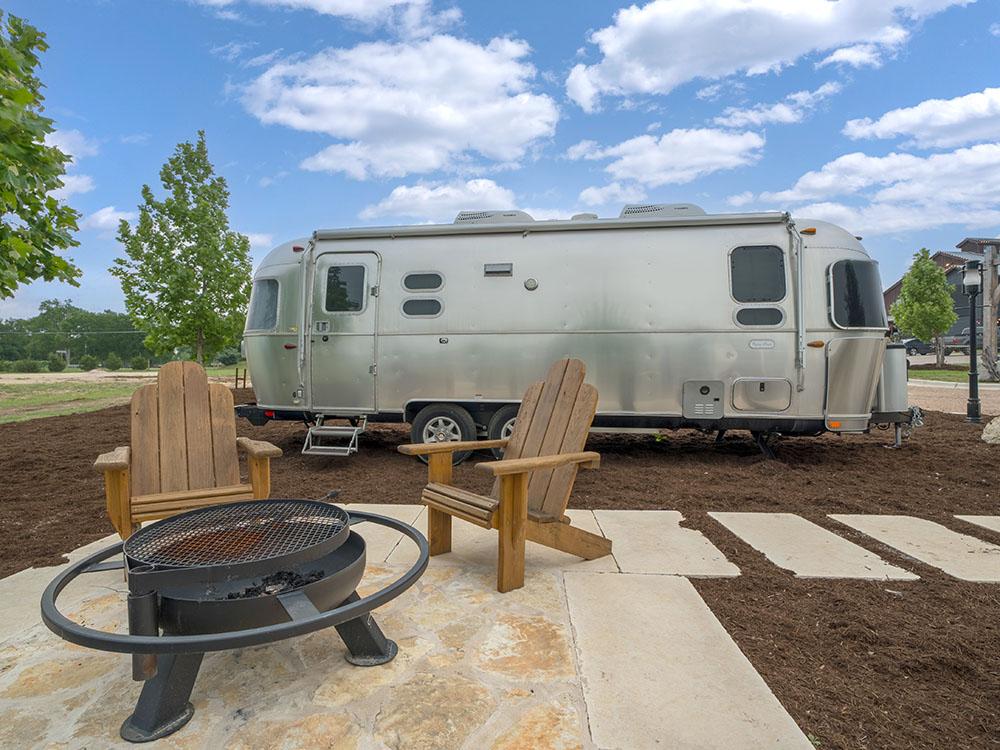 Airstream with fire pit and seating on patio at site at STARDUST AIRSTREAM RV RESORT AT CEDAR BREAK LODGING