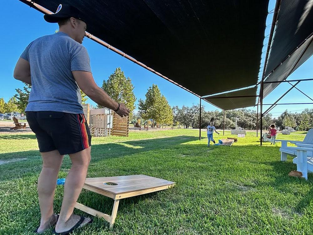 Family playing corn hole at STARDUST AIRSTREAM RV RESORT AT CEDAR BREAK LODGING