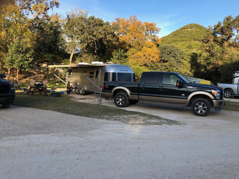 Airstream in site near picnic table at LOST MAPLES RV AND CAMPING