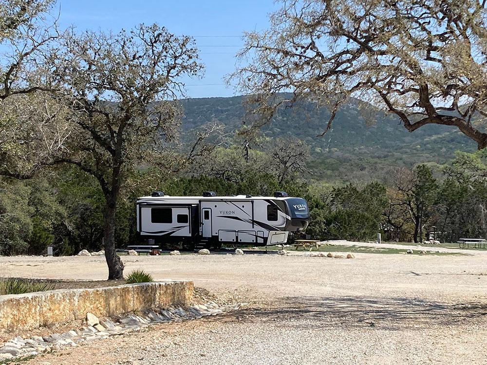 View of green hills beyond a fifth-wheel at LOST MAPLES RV AND CAMPING