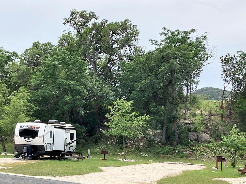 Travel trailer at site with trees and picnic table at LOST MAPLES RV AND CAMPING