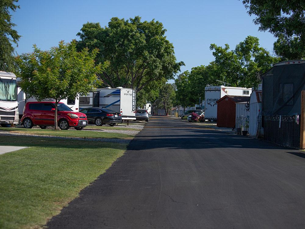 Paved road lined with grass and RVs at ROSEDALE VILLAGE RV PARK