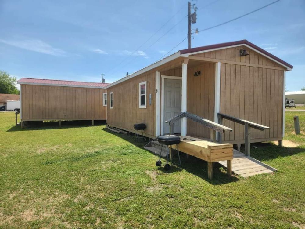 Two rentals surrounded by grass at The Bunkhouse Cabins and RV Park